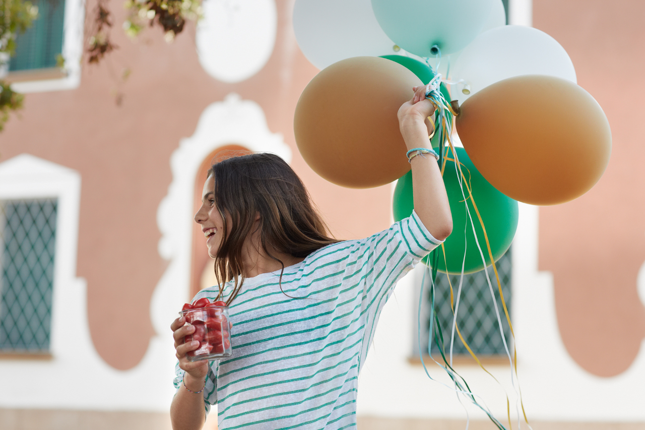 Cute girl with balloons and tomatoes for a party