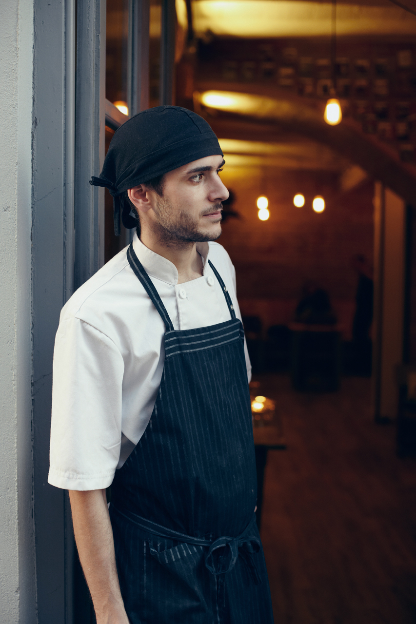 Portrait of a cook at the front door of the restaurant